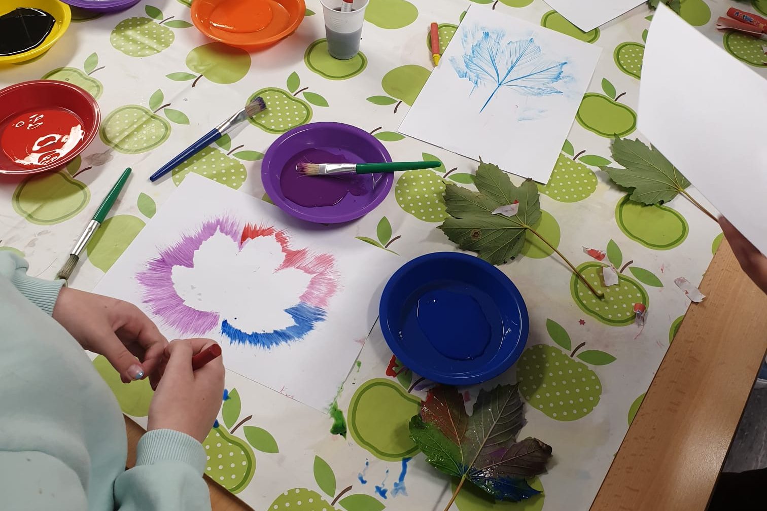 Leaf paintings and paints on a table at the Junior Youth Club